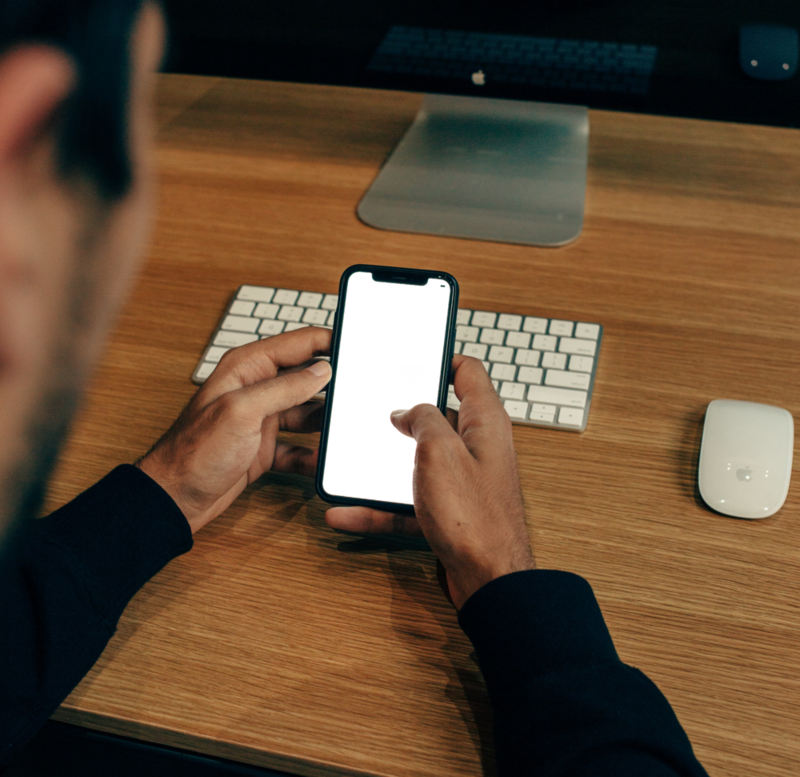 Desktop Mockup: man using phone near desktop pc