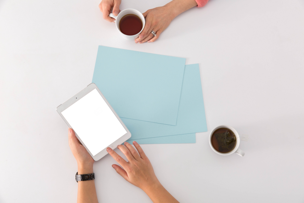 Tablet Mockup: hands in a meeting with coffee and ipad